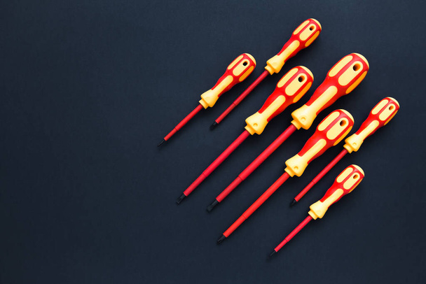 Screwdrivers. A set of bright colored screwdrivers on a dark background. Repair and renovation concept. Copy space. - Foto, Imagen