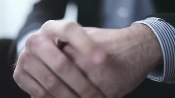 Vértes kaukázusi férfi fényes szobában ülő kezében - Felvétel, videó