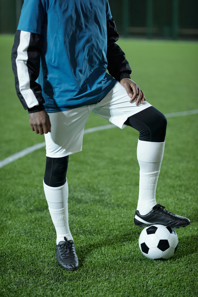 Mladý africký fotbalista v uniformě udržet nohu na fotbalovém míči - Fotografie, Obrázek