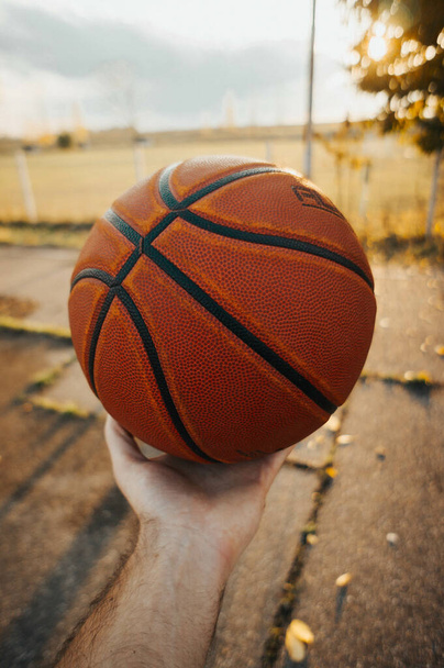 A vertical shot of a male hand holding a basketball - 写真・画像