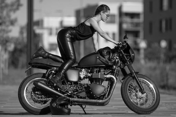 young beautiful girl in black with a motorcycle - Photo, Image