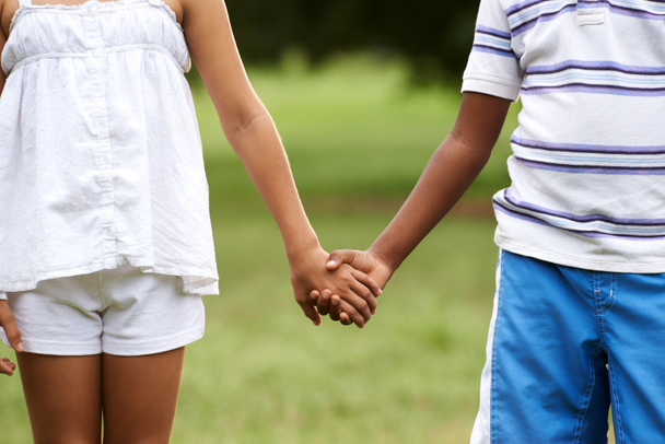 Дети любят черного мальчика белая девушка, держась за руки
 - Фото, изображение
