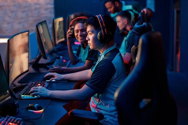 Jonge gamers in headsets spelen in video game club - Foto, afbeelding