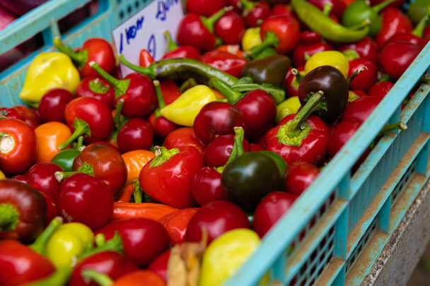 A closeup shot of a pile of colorful peppers at a market - Fotó, kép