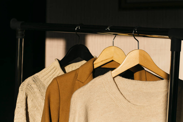 rack avec vêtements et cintres sur fond en bois - Photo, image