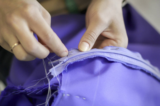Womens hands sew a skirt. Sew on the zipper. Handmade work.  - Foto, Bild