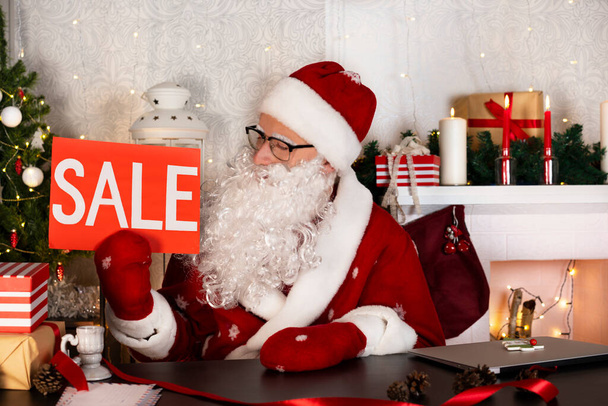 Merry Christmas Holiday Sale discount. Santa Claus holding sale sign. Shopping and marketing concept. - Foto, Imagen