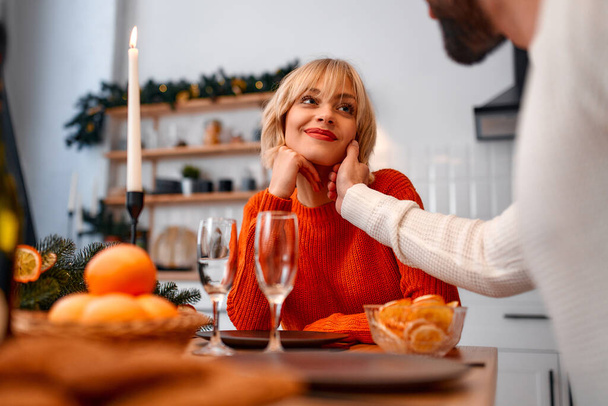 Joyeux Noël et bonne année ! Un jeune couple amoureux dans la cuisine lors d'un dîner festif romantique, en attente de la venue des vacances. - Photo, image