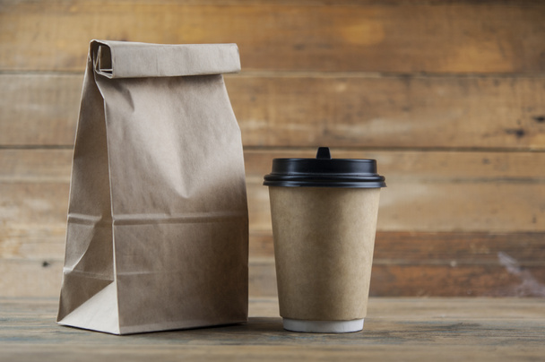 Emporter tasse à café en papier avec sac à lunch sur fond en bois - Photo, image