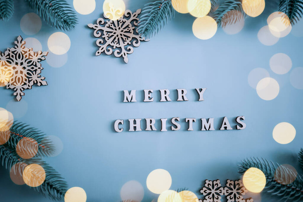 Cartas de madera con palabra Feliz Navidad sobre fondo azul claro. Tarjeta de felicitación de Navidad. Color rústico, estilo vintage. Decoración de Navidad, Árbol de Navidad, Copos de nieve de madera, Guirnaldas - Foto, Imagen
