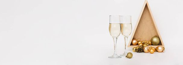 Šampaňské dvě sklenice, vánoční stromeček, hračky světlé pozadí.Slavnostní koncept zimních svátků Vánoce a Nový rok - Fotografie, Obrázek