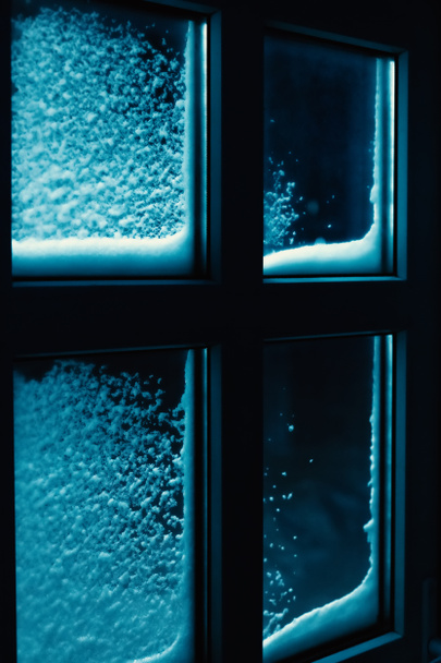 Zasněžené okenní rámy v zimním večeru. Měsíc svítí oknem. Záhadné vánoční pozadí. - Fotografie, Obrázek