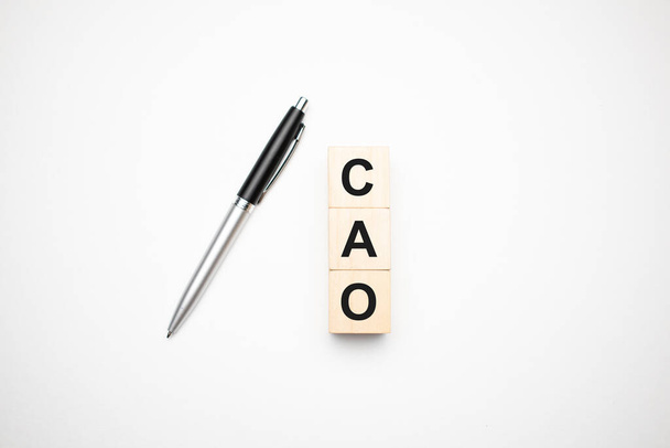 cao is made up of wooden cubes that stand on a burgundy notebook near the pen. Business concept - Foto, Imagen