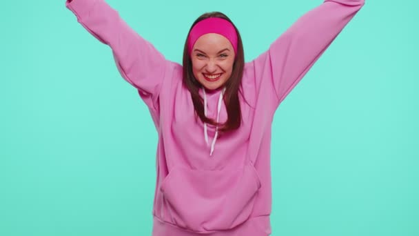 Chica adolescente con capucha rosa gritando, levantando los puños en gesto lo hice, celebrando el éxito, ganando - Imágenes, Vídeo
