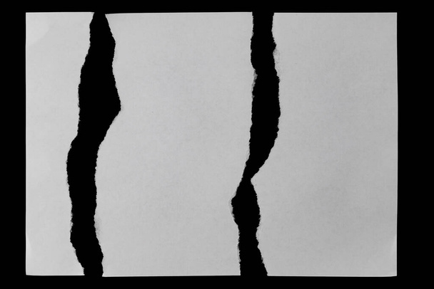 wit papier vellen met rafelranden geïsoleerd op een zwarte achtergrond - Foto, afbeelding