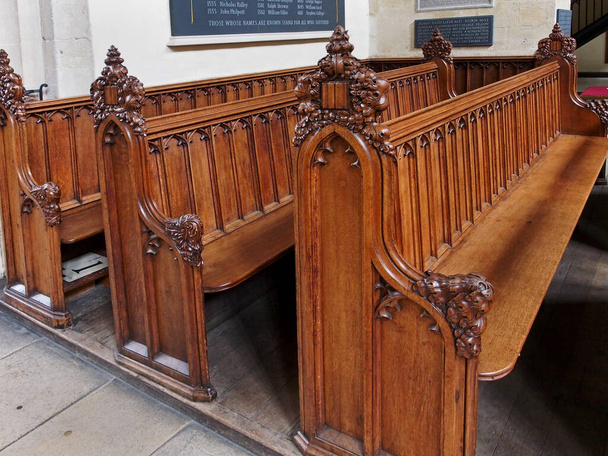 OXFORD - JULHO 2013: bancos de madeira esculpidos em St. Mary 's, a igreja universitária medieval, e placas comemorativas para mártires e doadores, como visto em Oxford por volta de 2013. - Foto, Imagem