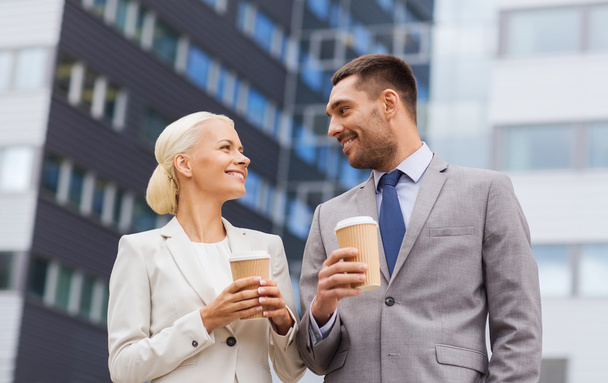 smiling businessmen with paper cups outdoors - Foto, afbeelding