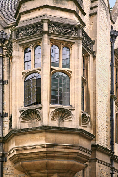 орієнтальне вікно будівлі готичного кам'яного коледжу
 - Фото, зображення