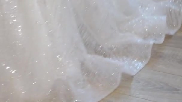 The bottom of the skirt of the bride's dress. The bride spins in a white glittering dress - Filmagem, Vídeo