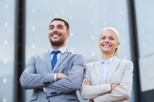 smiling businessmen standing over office building - Foto, afbeelding
