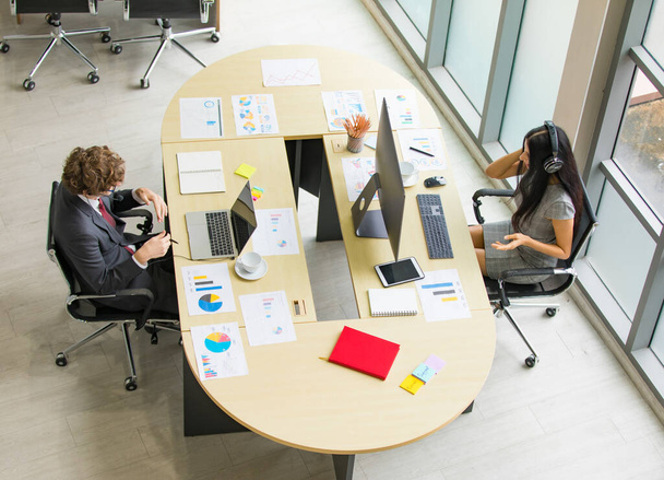 Профессиональная кавказская команда маркетологов проводит онлайн-деловую встречу творческого планирования на ноутбуке и настольном компьютере за рабочим столом офиса с портфолио-бумагой и стационарными - Фото, изображение