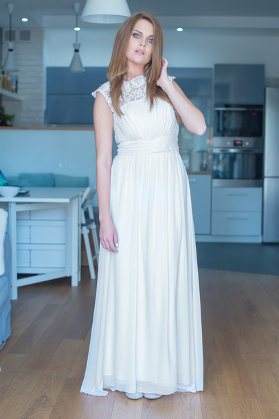Жінка в довгій білій сукні стоячи
 - Фото, зображення