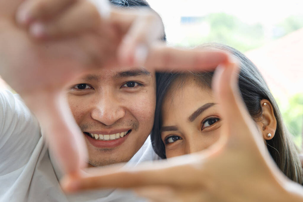 Close up di giovane coppia asiatica fare quadrato mano simbolo insieme mostrando romantico gesto. - Foto, immagini
