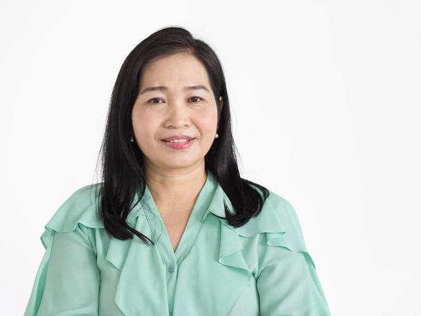 Портрет азиатки средних лет, одетой в мятно-зеленую блузку, красиво улыбающейся и уверенно изолированной. - Фото, изображение