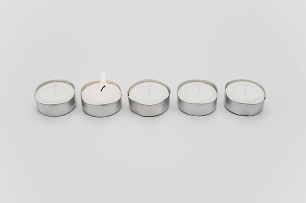 row of white scented wax tea lights on a white tabletop with copy space - Φωτογραφία, εικόνα