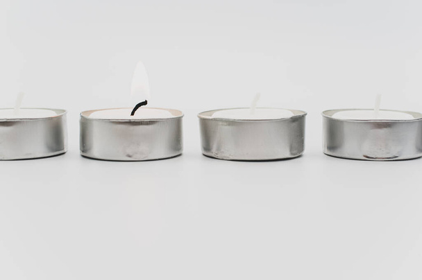 row of white scented wax tea lights on a white tabletop with copy space - Photo, Image