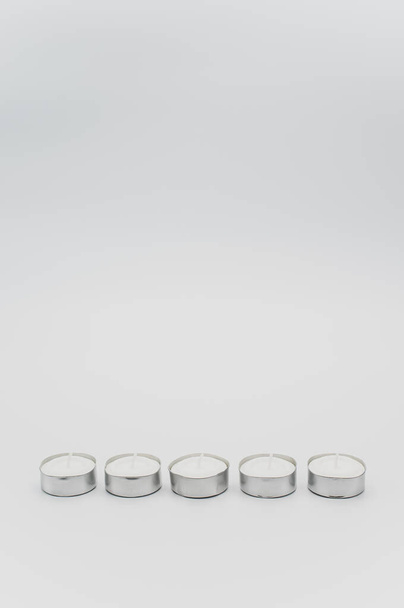 row of white scented wax tea lights on a white tabletop with copy space - Valokuva, kuva