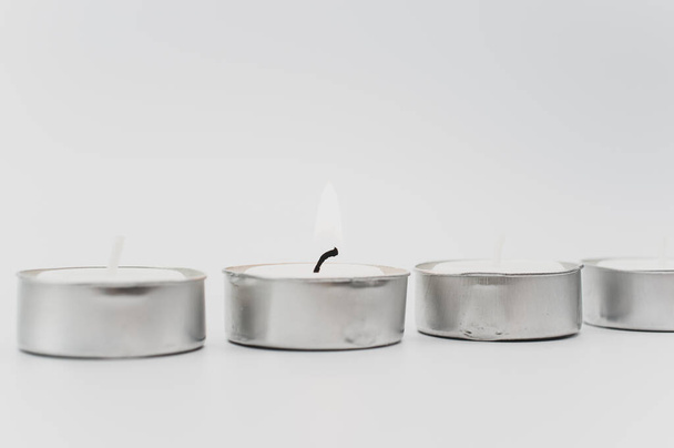 row of white scented wax tea lights on a white tabletop with copy space - Fotó, kép