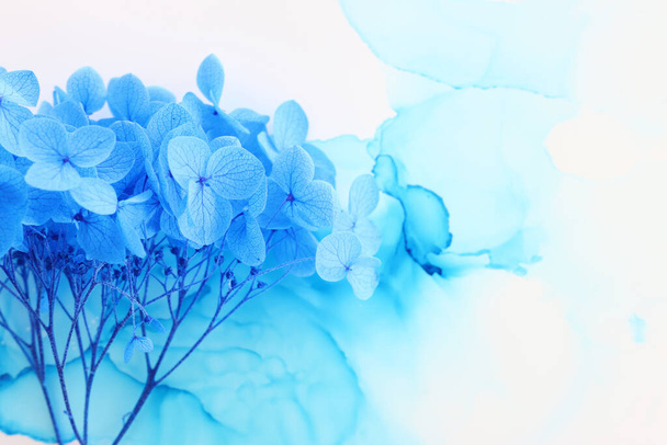 Creative image of blue Hydrangea flowers on artistic ink background. Top view with copy space - Фото, изображение