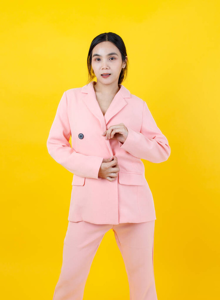 Cute and sexy Asian girl fasten button of gorgeous pink business jacket and smile with confident on posing amazing outfit for modern working woman fashion and lifestyle. Attractive adult clothing. - Fotó, kép