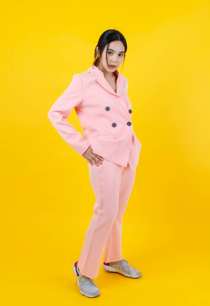 Attractive and cute Asian girl on beautiful pink business jacket, pants, and sneakers easily walking and smile as pretty model for woman beauty, clothing, outfit fashion and female lifestyle. - Photo, Image