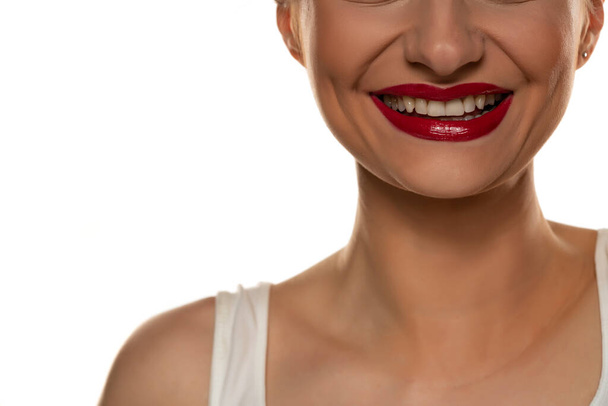 bílé zuby, široký úsměv a červená rtěnka na bílém pozadí - Fotografie, Obrázek