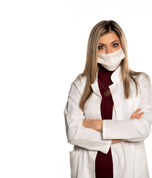 Young confident female doctor with  face medical mask on a white background - Photo, Image