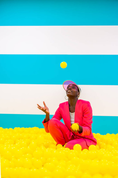 Beautiful african american young woman dancer having fun inside a rainbow box room - Cool and stylish afro adult woman portrait on multicolored background, influencer creating content for social networks in a selfie room - Foto, Imagen