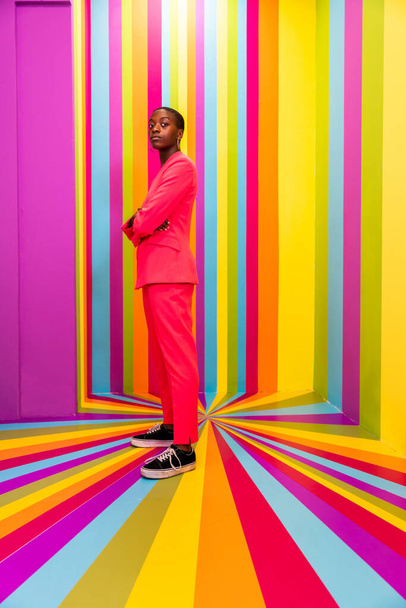Beautiful african american young woman dancer having fun inside a rainbow box room - Cool and stylish afro adult woman portrait on multicolored background, influencer creating content for social networks in a selfie room - Фото, зображення