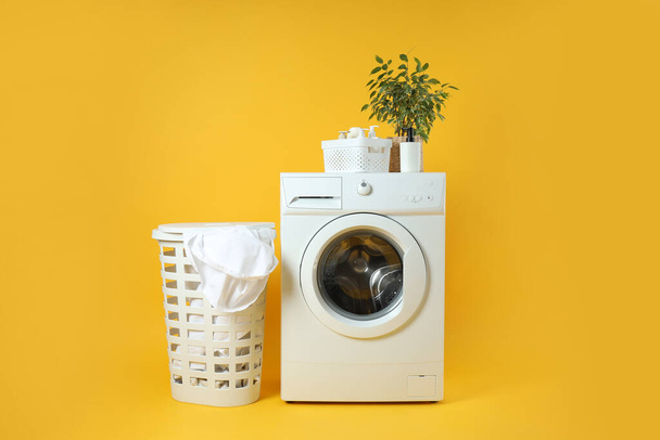 Concetto di lavori domestici con lavatrice su sfondo giallo - Foto, immagini