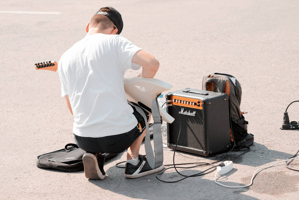 21 August 2021, Ufa, Russia: A street guitarist tunes up a Marshall guitar amp before performing. Sound check and equipment - Foto, Imagem