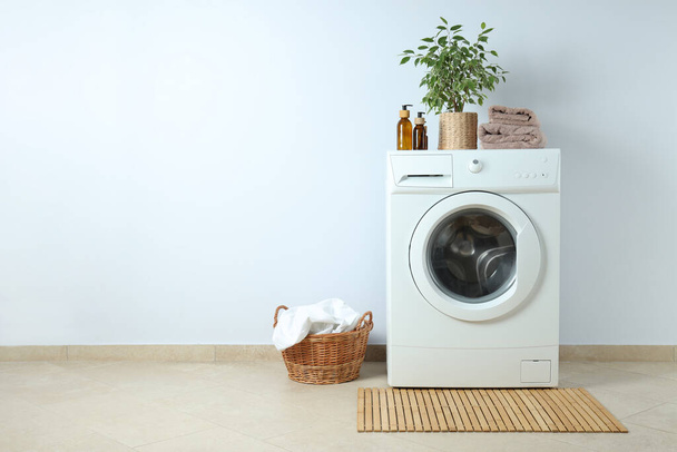 Concept of housework with washing machine against white wall - Photo, Image