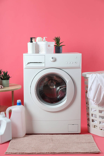 Έννοια της οικιακής εργασίας με πλυντήριο σε ροζ φόντο - Φωτογραφία, εικόνα