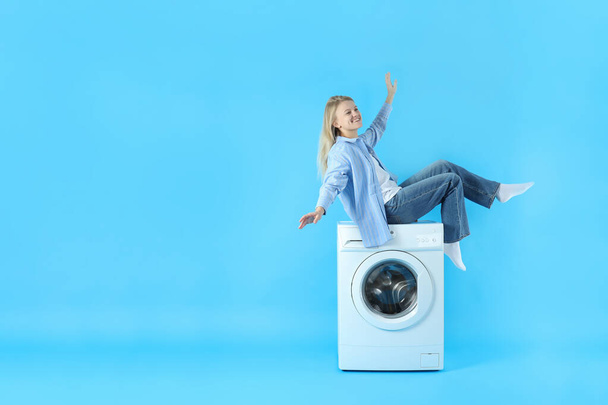 Conceito de trabalho doméstico com máquina de lavar roupa e menina no fundo azul - Foto, Imagem