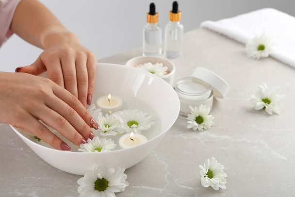 Gri desenli masa üzerinde kozmetik ürünlerle el bakımı kavramı - Fotoğraf, Görsel