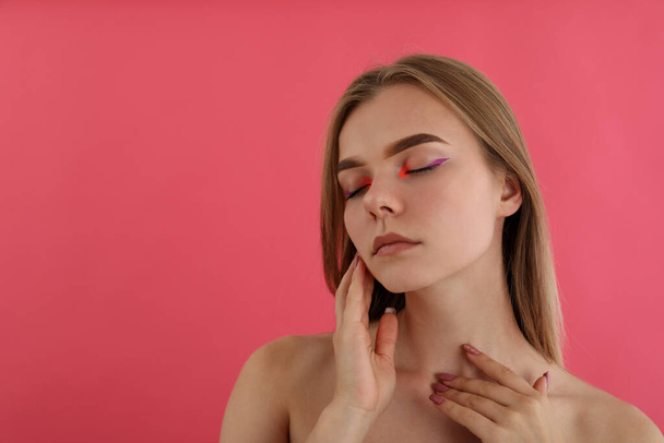 Красивая модель девушка с макияжем на розовом фоне - Фото, изображение