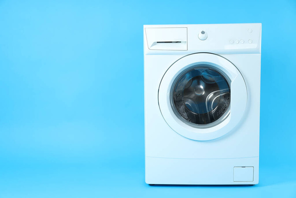 Moderne witte wasmachine op blauwe achtergrond - Foto, afbeelding