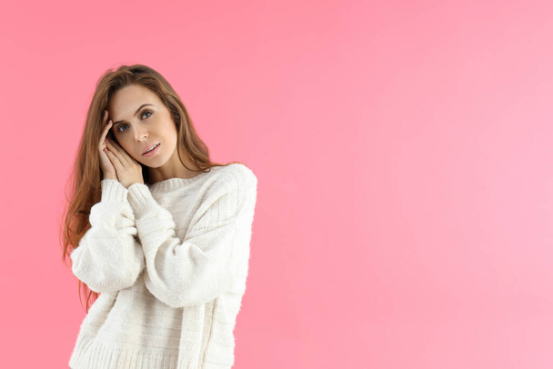 Attractive woman in sweater on pink background - Фото, изображение