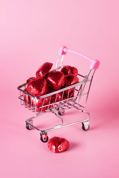 Red Chocolate Candy in Shape of Hearts in Mini Shopping Cart on the background for valentines day Vertical - Foto, Bild