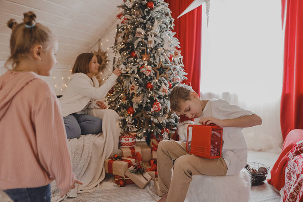 Милые дети упаковывают рождественские подарки, крупным планом. Упаковка подарков. Семья, зимний отдых и люди - Фото, изображение